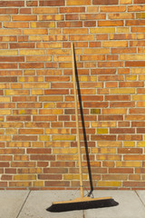Besen vor Mauer hoch