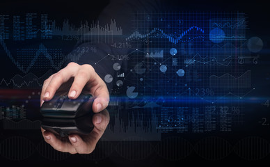 Hand using wireless mouse with financial concept on dark background
