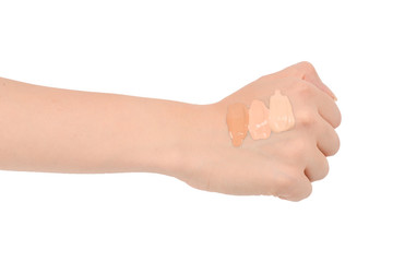 Fair, medium, dark swatches  of foundation on the hand isolated on white.
