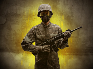 Fototapeta premium Hazard, menace soldier in a ruined crumbly building with arms on his hand 