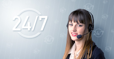 Young female telemarketer with a 24/7 sign next to her
