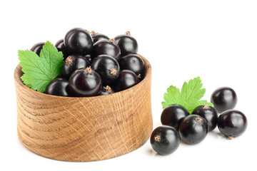 black currant with leaf in wooden bowl isolated on white background