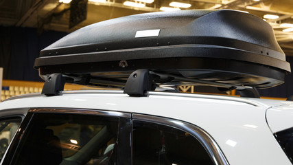 Car with the roof rack with cargo box. Luggage box mounted on the roof of a car
