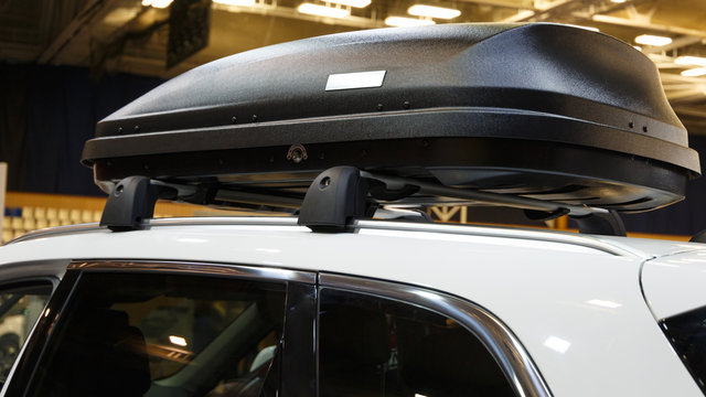 Car With The Roof Rack With Cargo Box. Luggage Box Mounted On The Roof Of A Car