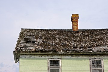 The weathered roof and chimney of an abandoned house on Tangier Island, in the Chesapeake Bay,...