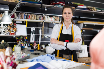 Portrait of woman designer who is standing on her workplace in time designing new collection