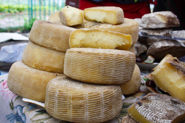Cylinder cheese wheels on top of each other.