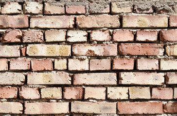 Red brick with mortar some of brick are slightly broken. Bricks are slightly brightened by the sun.
