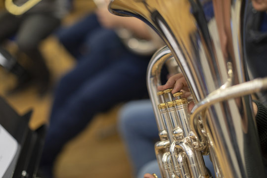 A Person Playing A Silver Plated Tuba In Rehearsal