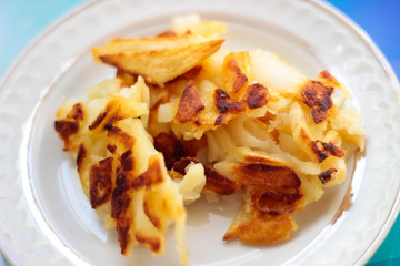 Fried potato on a plate, tasty lunch.