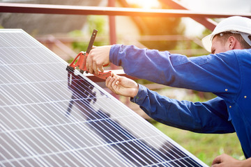 Process of connecting solar photo voltaic panel by professional technicians outdoors on bright...