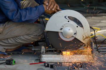 Worker cut steel pipe in workshop.