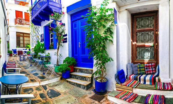 Fototapeta Traditional narrow streets with cute cafe bars in Greece. Skopelos island