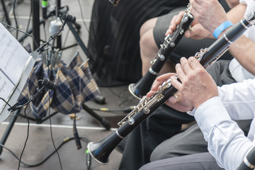Men play the clarinet in the orchestra. People play on wind instruments - obrazy, fototapety, plakaty