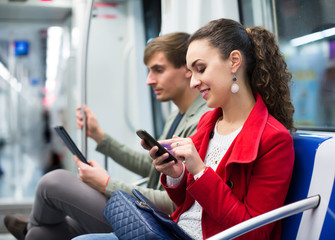 Happy couple reading smartphone and e-book