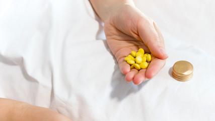 Closeup image of female hand holding big heap of yellow pills