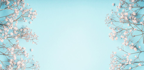 Obraz na płótnie Canvas Light blue floral background frame with white Gypsophila flowers. Baby's-breath flowers on pastel blue layout , banner