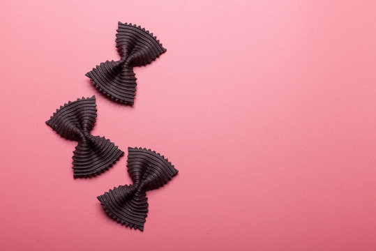 Black Pasta Farfalle On Pink Background