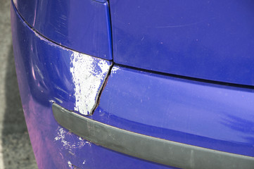 Blue scratched car with damaged paint in crash accident or parking lot and dented damage of metal...
