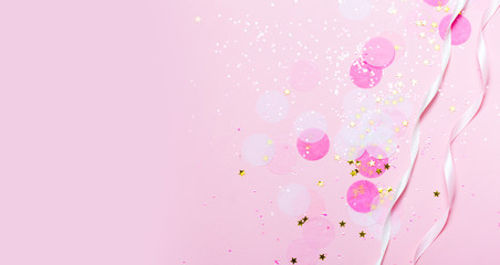 Pink confetti and stars and sparkles on pink background.