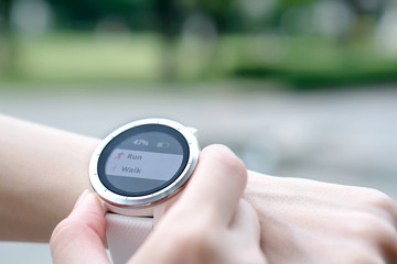 Woman running outdoors using watch