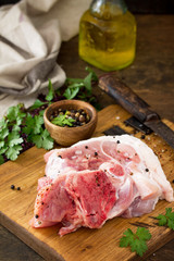 Fresh raw meat. Raw pork meat steak with olive oil, spices and herbs on wooden table.