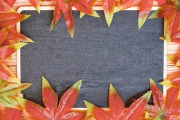 Autumn Maple leaves and chalkboard with handwritten words on wooden background. Top view and Copy space for your text