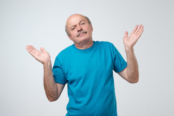Fototapeta premium Who knows and it was not me concept. Puzzled bald caucasian man is not sure in his testimony. Studio shot