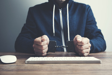 man in handcuffs in front of computer