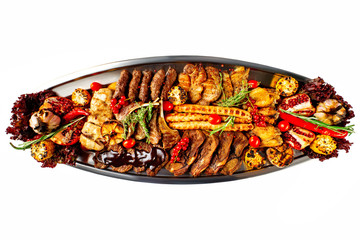 Closeup metal dish of meat assortment set of grilled pork, beef, chicken with vegetables isolated at white background.