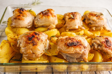 Homemade baked potatoes with chicken in a glass dish. Simple home cooking concept.