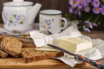 Sliced rye bread with butter on a wood board