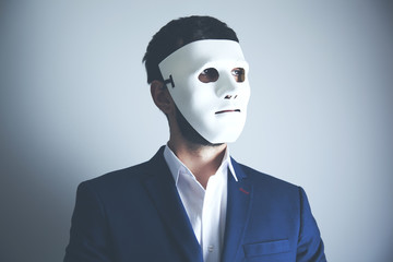 man holding white mask for hide his face