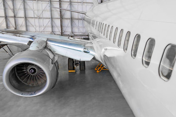 Passenger airplane on maintenance of jet engine and aircraft hangar.