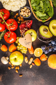 Vegan food ingredients on a dark background. Vegetables, fruits, cereals, nuts, beans top view.