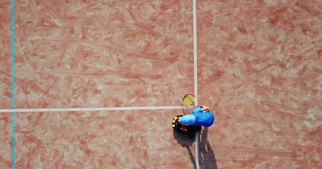 Little boy playing tennis. Little boy in tennis serving. Aerial view.