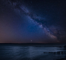 Vibrant Milky Way composite image over landscape of Beautiful sea looking across Solent to Isle of Wight in England