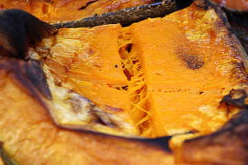 Organic Pumpkin slice baked for Halloween holiday. Colorful baked squash background. Pumpkin...