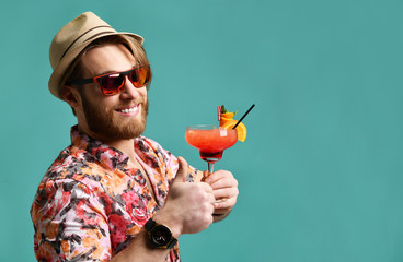 Young man in hat show thumb up drinking red margarita cocktail drink juice happy looking at camera...