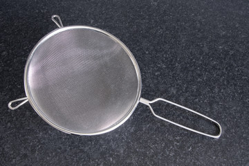 Kitchen sieve on a dark counter top
