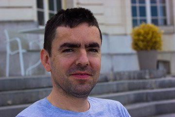 unshaven middle-aged man in a dreamy smile