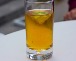 carbonated beverage of amber color with lime in a glass goblet