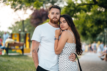 Handsome guy hugging his girlfriend in the park.