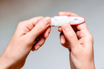 Pregnancy test in woman's hand. Shallow depth of field.