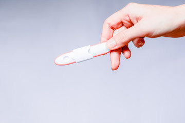 Pregnancy test in woman's hand. Shallow depth of field.