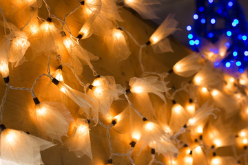Christmas lights in the form of leaves on wooden background with copy space. Decorative garland.
