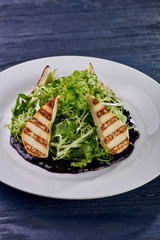 A mountain of greenery, arugula, lettuce with an abundance of unusual berry, blueberry sauce. Thin slices, chicken, white meat, fish, grilled. Dietary salad for those who lose weight.