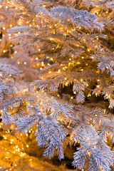 Silver Christmas tree with golden shining garlands, Christmas background. Vertical