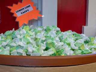 Lemon lime flavored taffy piled in a barrel with sign in store