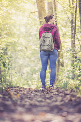 Junge Frau steht nachdenklich und allein im Wald wandern, Orientierung